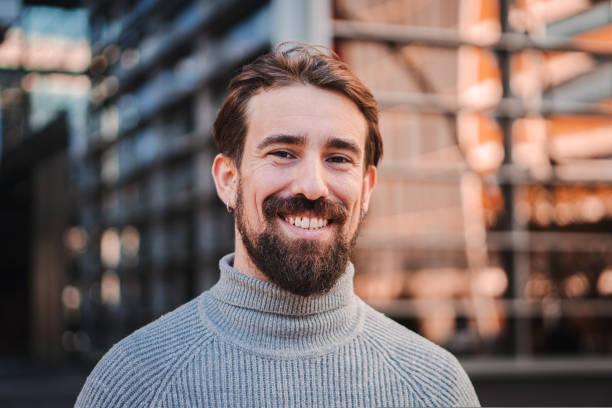 Photo of a cheerful man with a beard in a sweater